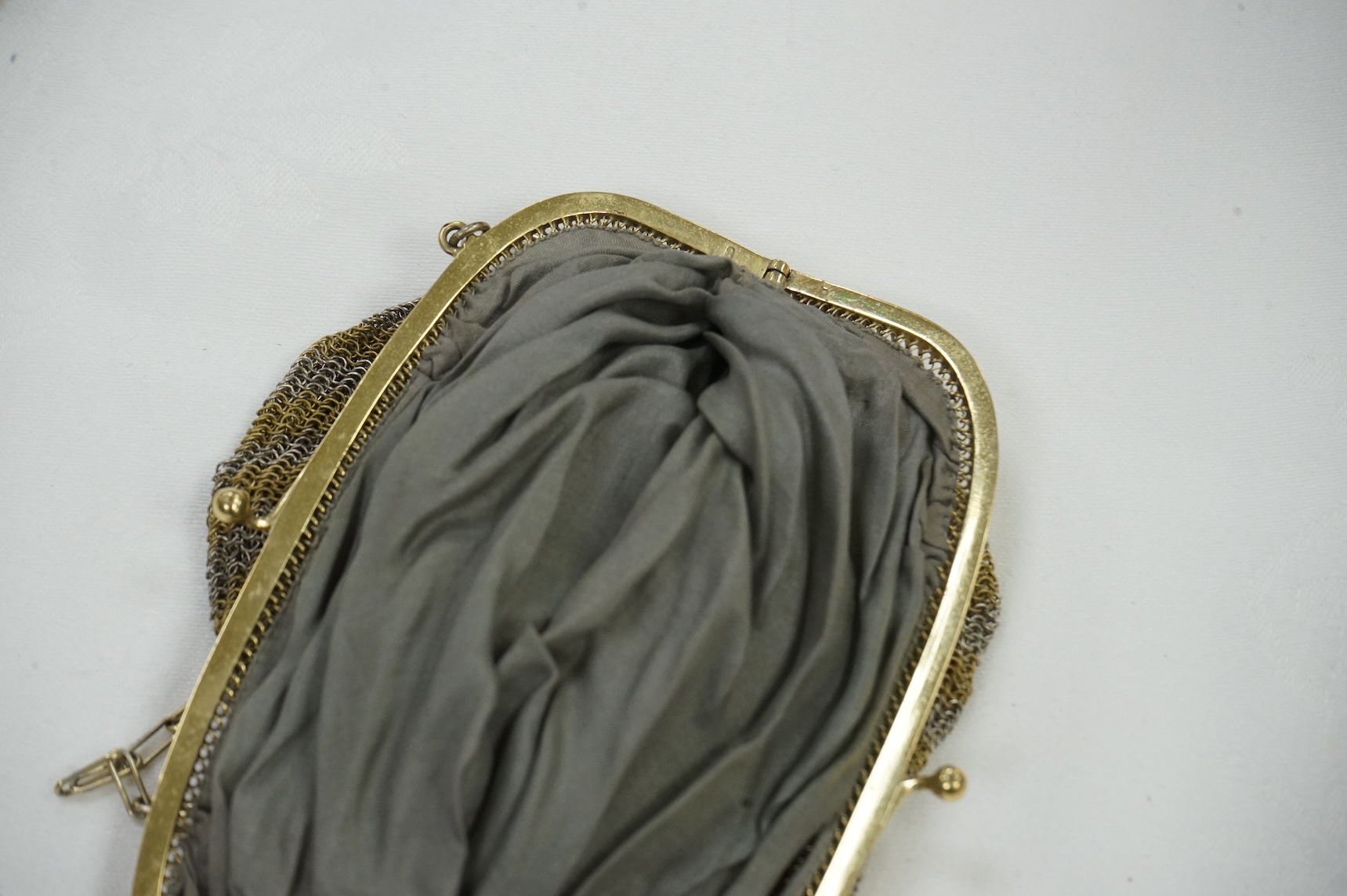 An Art Deco coloured metal chain mail evening bag together with a silver metal bead, blue clasped evening bag and smaller purse., Chain mail bag 13.5cm high. Condition - good on all three.